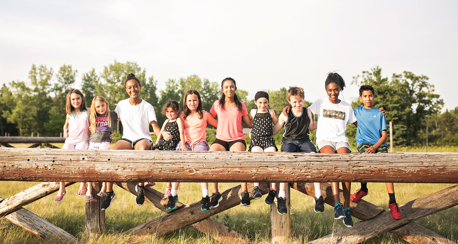 Several students sitting together with their arms around each other smiling